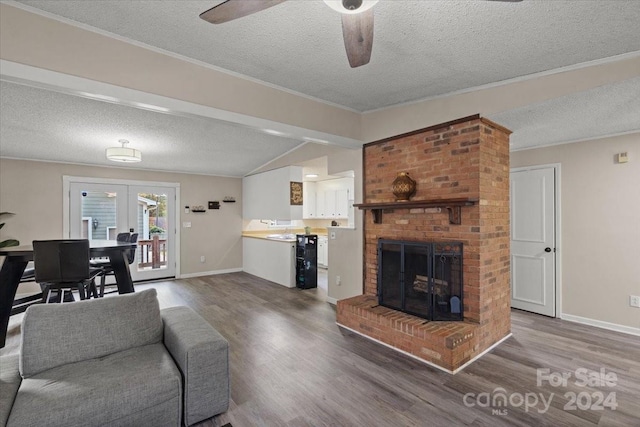 living room with wood-type flooring, a textured ceiling, lofted ceiling with beams, and ceiling fan