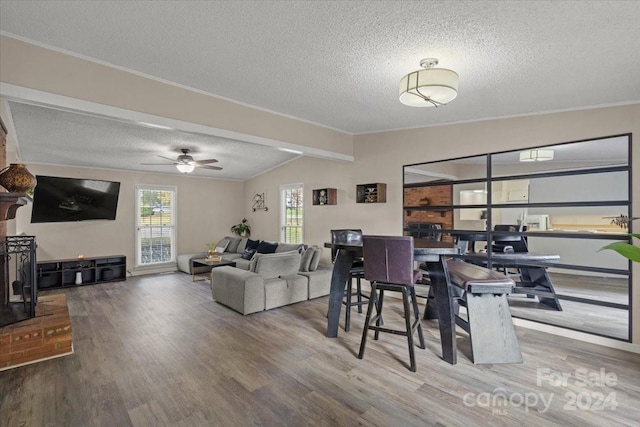 dining room featuring hardwood / wood-style floors, a textured ceiling, ceiling fan, and vaulted ceiling with beams