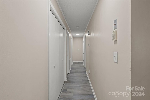 hallway with hardwood / wood-style floors and a textured ceiling