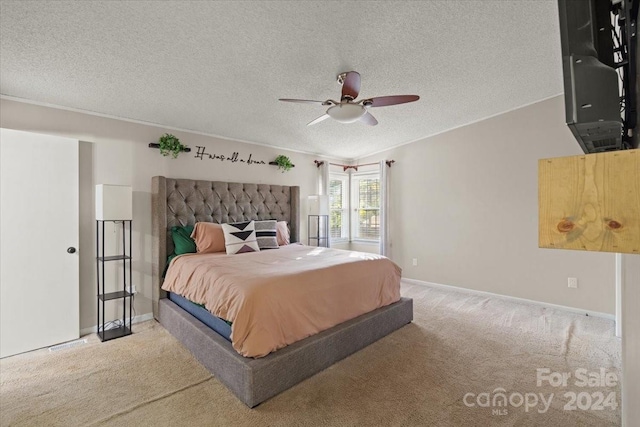 carpeted bedroom with ceiling fan and a textured ceiling