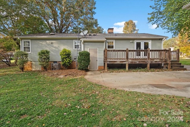 rear view of property with a wooden deck and a yard