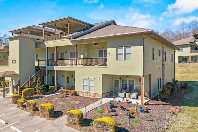 view of front facade with a patio, ceiling fan, and a balcony