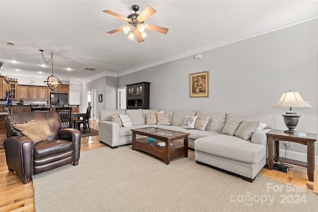 living room featuring crown molding, light hardwood / wood-style flooring, and ceiling fan