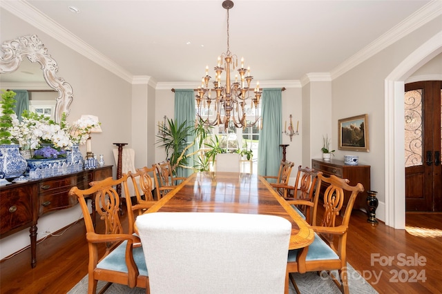 dining area featuring hardwood / wood-style floors, an inviting chandelier, and crown molding