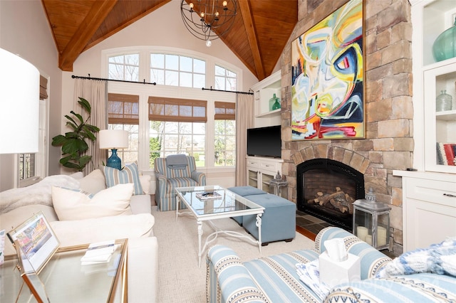 living room featuring a stone fireplace, high vaulted ceiling, a chandelier, and wooden ceiling