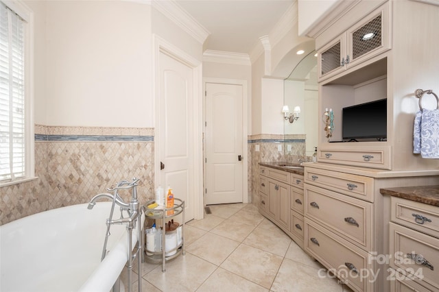 bathroom featuring vanity, a bathtub, tile walls, and crown molding