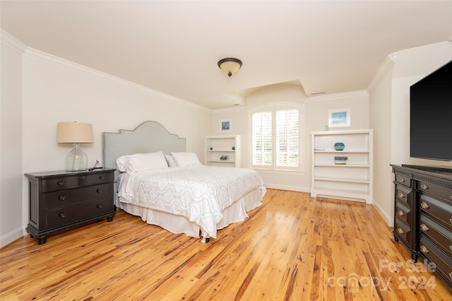 bedroom with light hardwood / wood-style flooring and crown molding