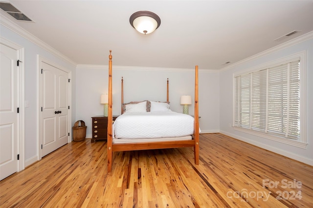 bedroom with light hardwood / wood-style floors and crown molding