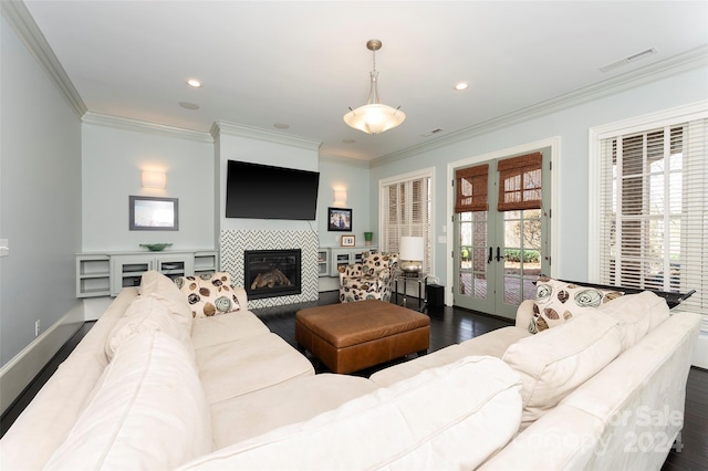 living room with a fireplace, dark hardwood / wood-style floors, french doors, and crown molding