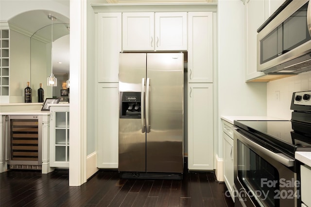 kitchen with dark hardwood / wood-style flooring, beverage cooler, appliances with stainless steel finishes, and white cabinets