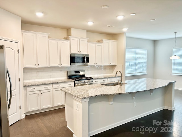 kitchen featuring white cabinets, dark hardwood / wood-style floors, hanging light fixtures, and appliances with stainless steel finishes