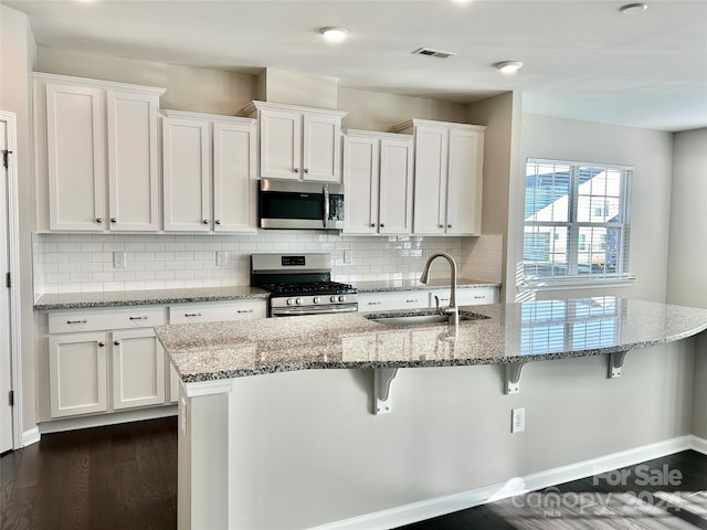 kitchen featuring white cabinets, stainless steel appliances, dark wood-type flooring, and sink