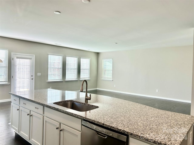 kitchen with sink, stainless steel dishwasher, dark hardwood / wood-style floors, light stone counters, and white cabinetry