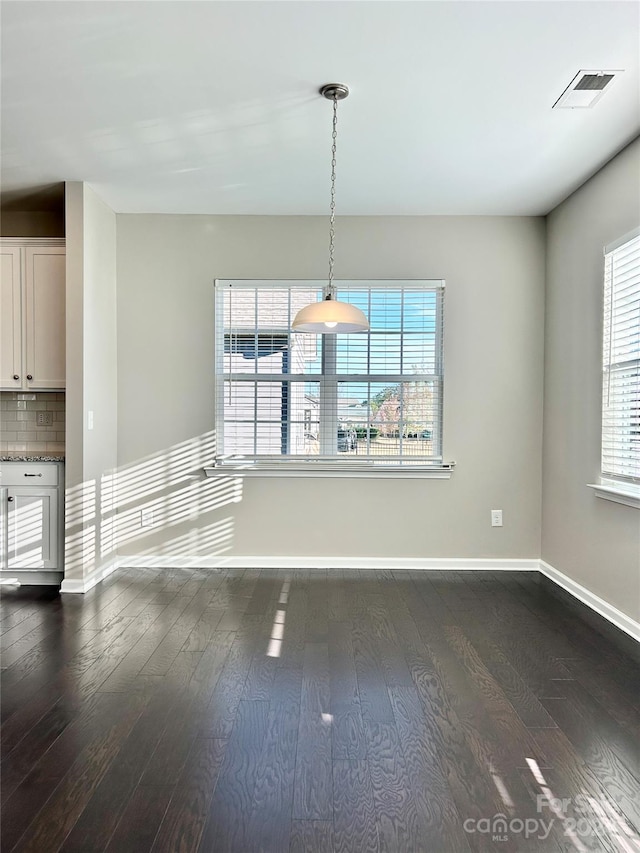 unfurnished dining area featuring dark hardwood / wood-style floors