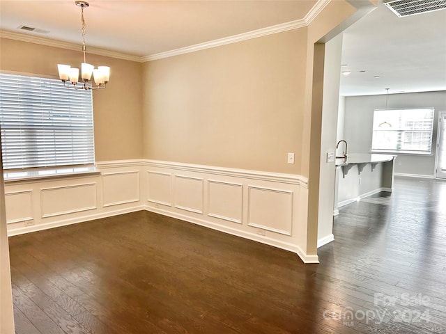 unfurnished room with a chandelier, ornamental molding, and dark wood-type flooring