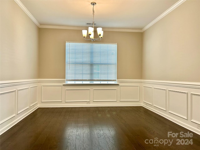 empty room featuring dark hardwood / wood-style floors, crown molding, and an inviting chandelier