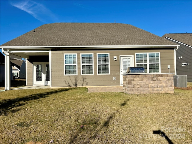 rear view of property with an outdoor kitchen, cooling unit, and a yard