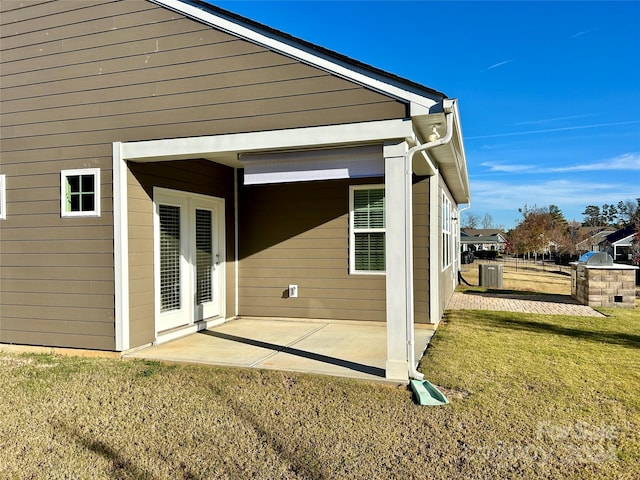 exterior space with a lawn, cooling unit, and a patio area