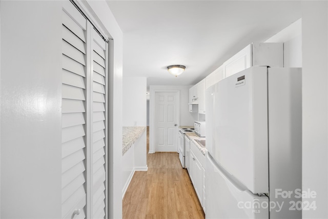 kitchen with light stone countertops, white cabinetry, light hardwood / wood-style flooring, and white appliances