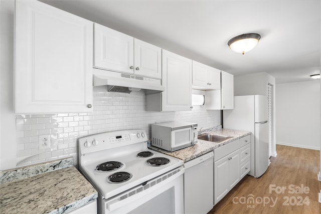 kitchen featuring white cabinets, light wood-type flooring, sink, light stone counters, and white appliances