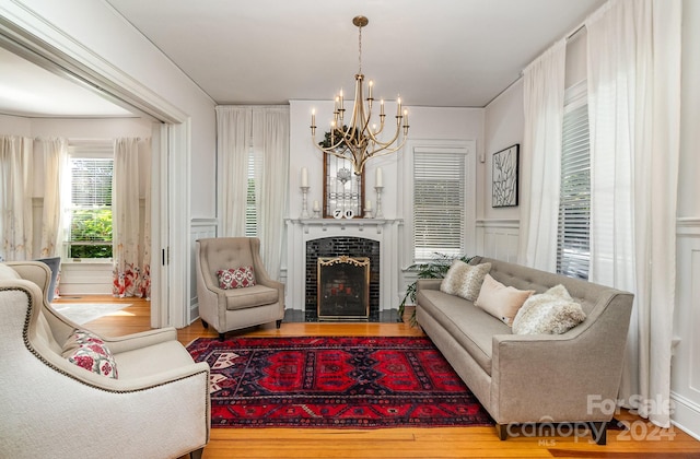 living room featuring an inviting chandelier, wood-type flooring, and a tile fireplace