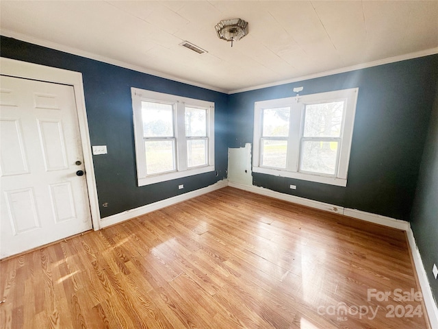 interior space with light wood-type flooring and crown molding