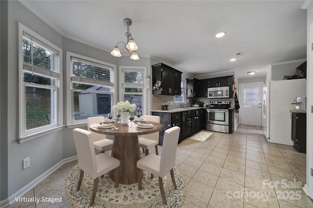 tiled dining space featuring ornamental molding, sink, and a notable chandelier