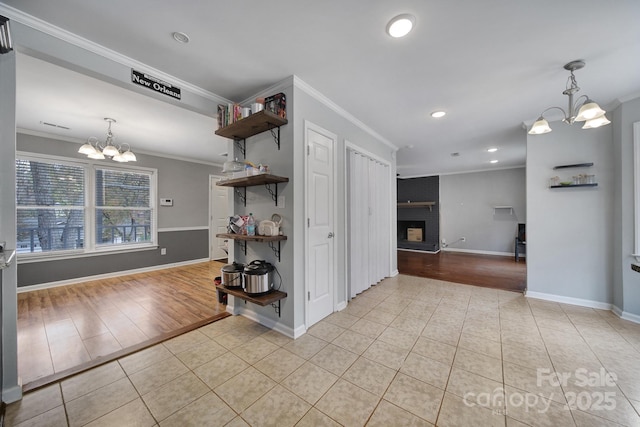 kitchen with crown molding, a fireplace, a chandelier, and light tile patterned floors