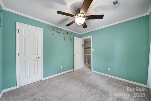 unfurnished bedroom featuring light colored carpet, ornamental molding, and ceiling fan