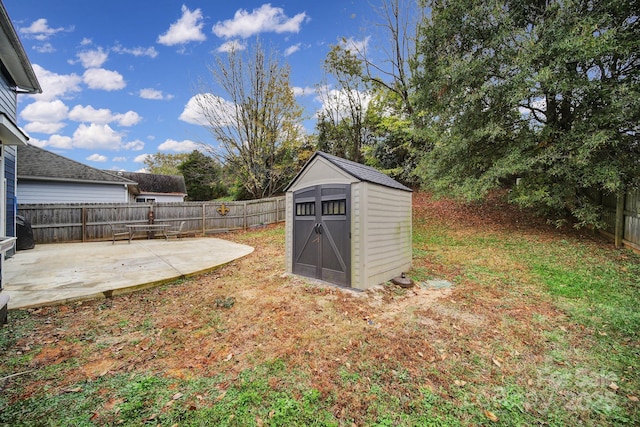 view of yard with a storage shed and a patio area