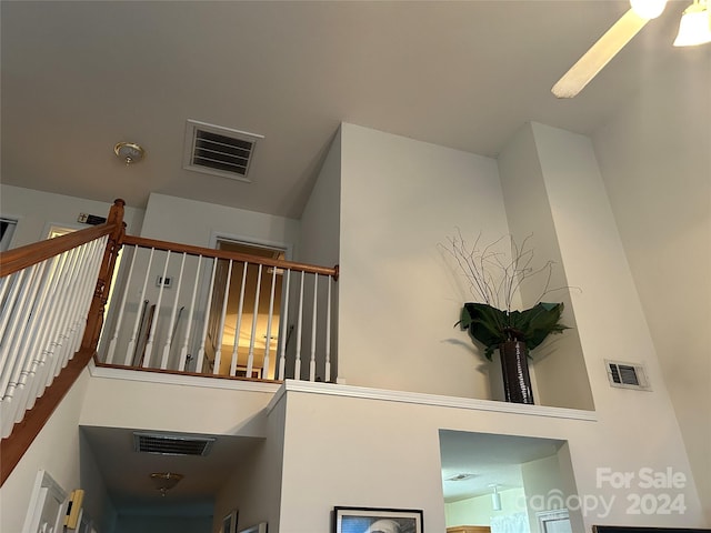 staircase with ceiling fan and a towering ceiling