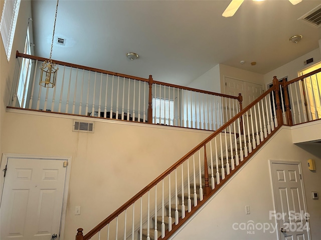 staircase featuring a high ceiling and a chandelier