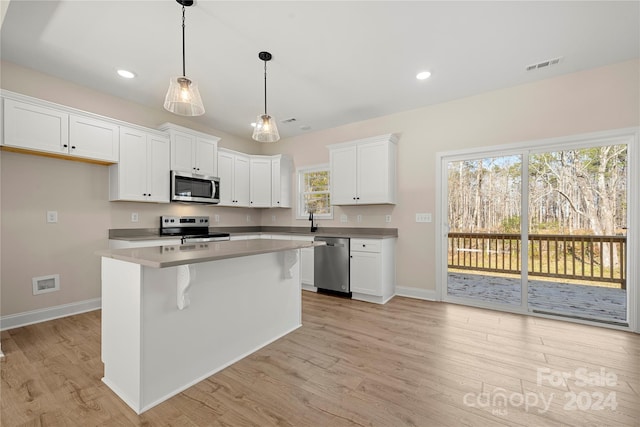 kitchen featuring a kitchen island, white cabinets, light wood-type flooring, and appliances with stainless steel finishes