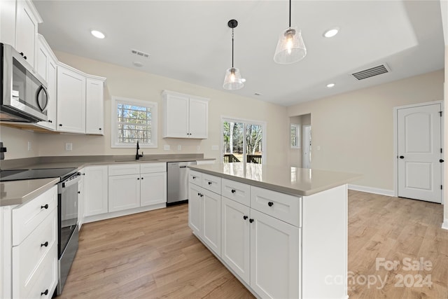 kitchen featuring a center island, stainless steel appliances, light hardwood / wood-style floors, and sink