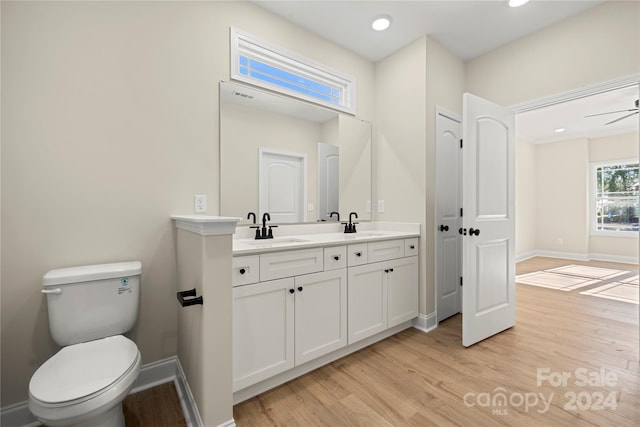 bathroom with vanity, hardwood / wood-style flooring, toilet, and ceiling fan