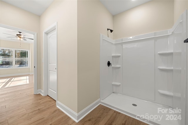 bathroom with a shower, hardwood / wood-style flooring, and ceiling fan