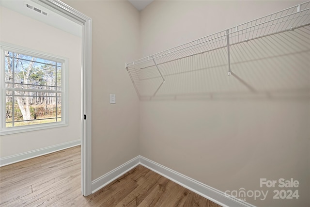 clothes washing area with hardwood / wood-style flooring