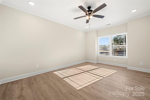 empty room featuring light wood-type flooring, baseboards, visible vents, and crown molding