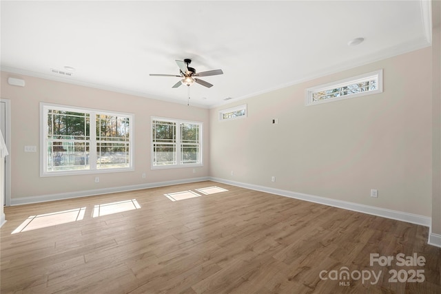 unfurnished room with ornamental molding, light wood-style flooring, visible vents, and baseboards