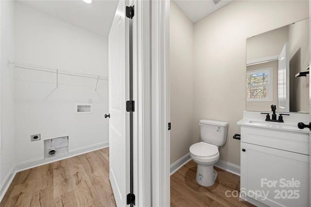 bathroom featuring vanity, wood finished floors, toilet, and baseboards