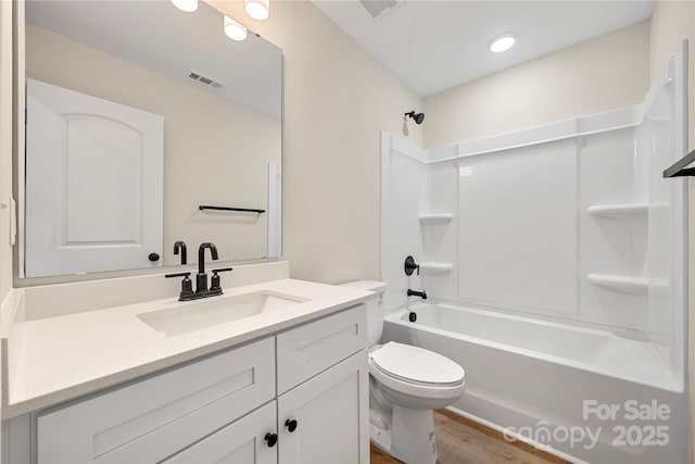 bathroom with washtub / shower combination, toilet, vanity, and visible vents