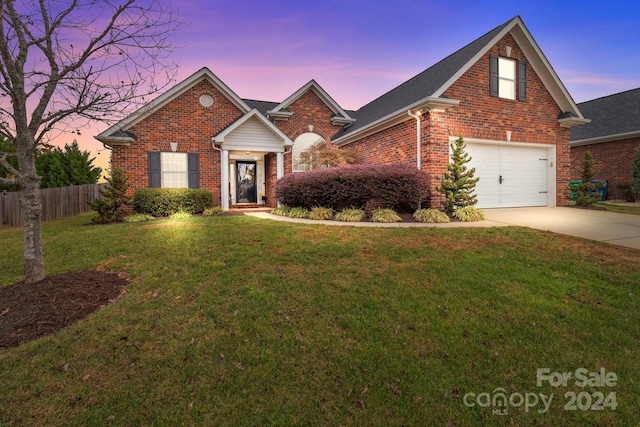 front facade featuring a lawn and a garage