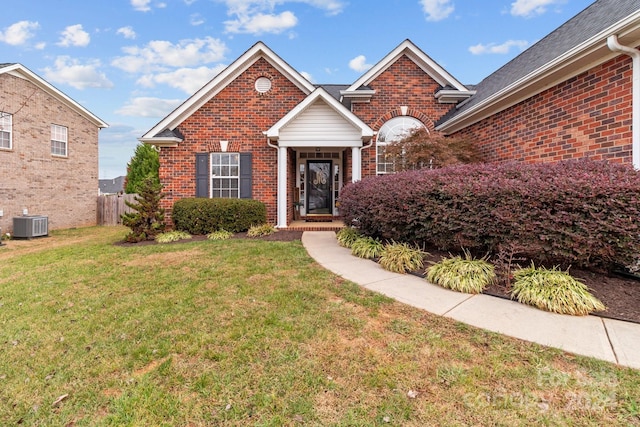 view of property featuring a front lawn and central AC unit