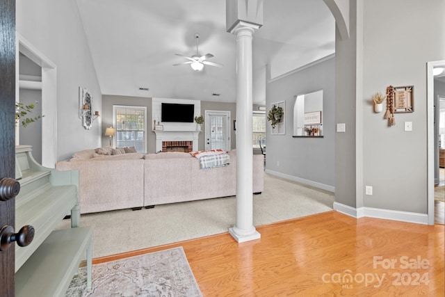 living room featuring ornate columns, a fireplace, ceiling fan, and hardwood / wood-style flooring