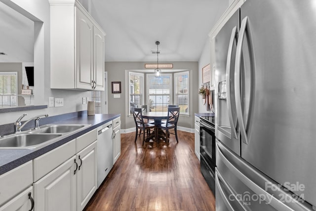 kitchen featuring stainless steel appliances, dark hardwood / wood-style flooring, pendant lighting, sink, and white cabinetry