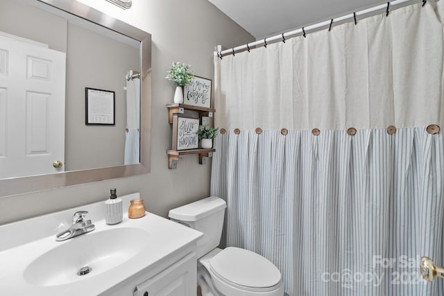 bathroom featuring walk in shower, vanity, and toilet