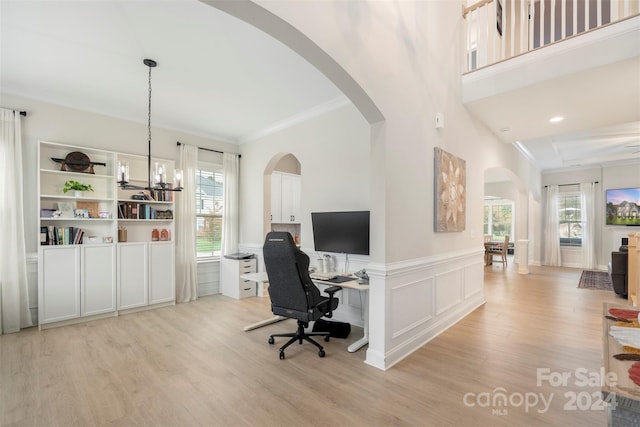 office featuring light hardwood / wood-style flooring, ornamental molding, and a notable chandelier