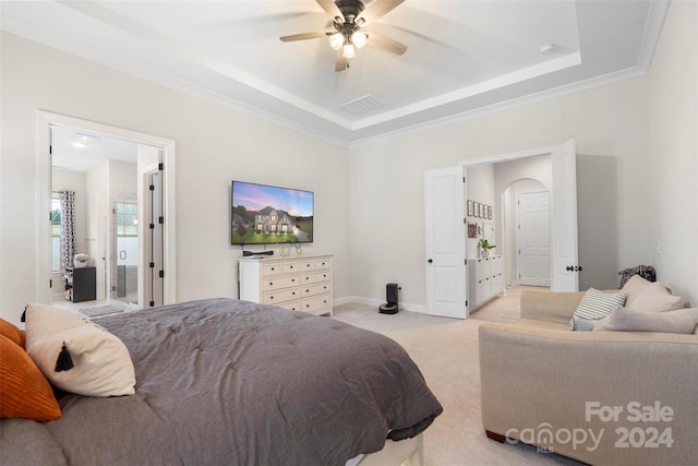 carpeted bedroom featuring crown molding, a tray ceiling, and ceiling fan