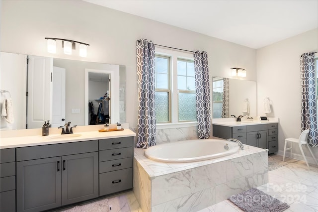 bathroom featuring vanity and tiled bath