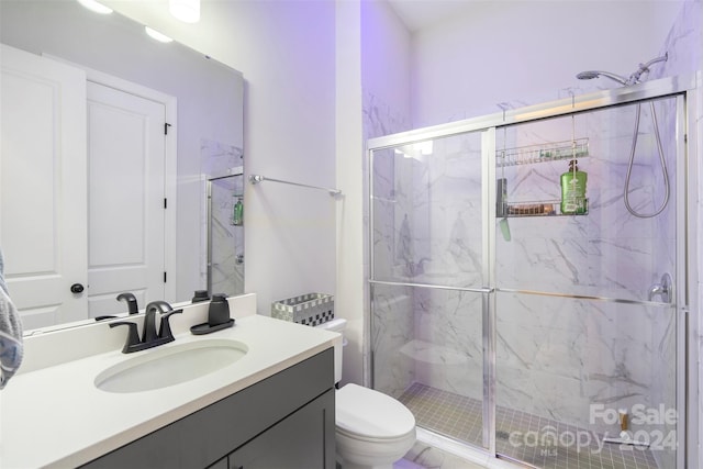 bathroom featuring vanity, an enclosed shower, and toilet